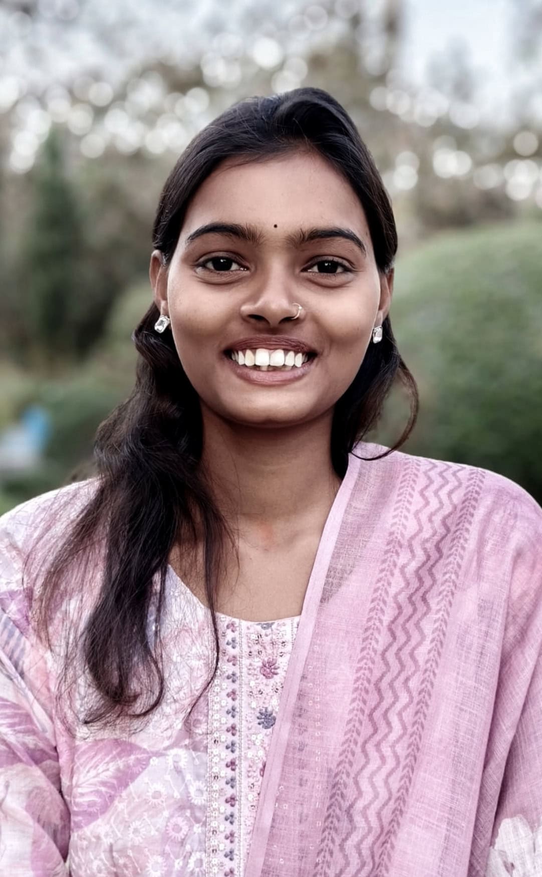 Smiling-Young-Woman-India-The-Hunger-Project-Community-Portrait Smiling young woman in India wearing a pink and white kurta, representing The Hunger Project community and adolescent girls programs